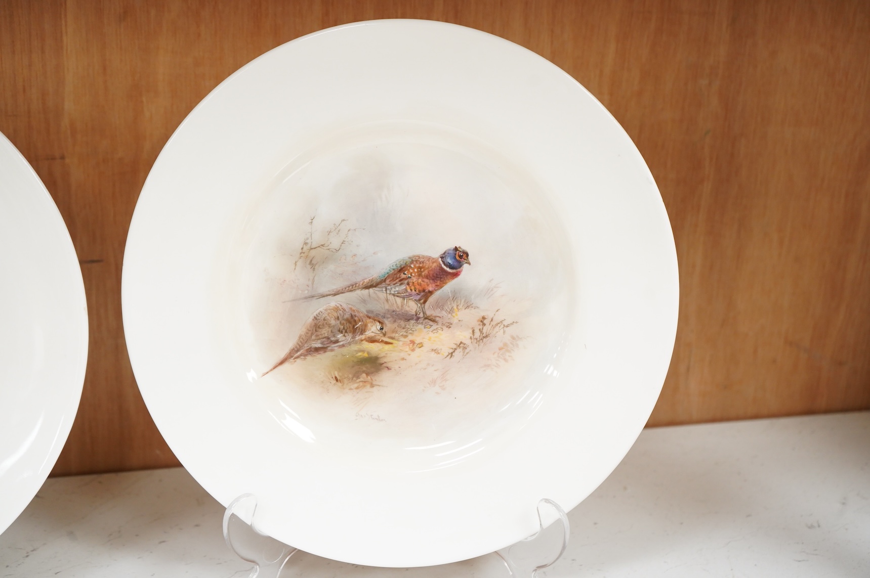 James Stinton for Royal Worcester, a pheasant painted plate, signed and a similar but unsigned ptarmigan plate